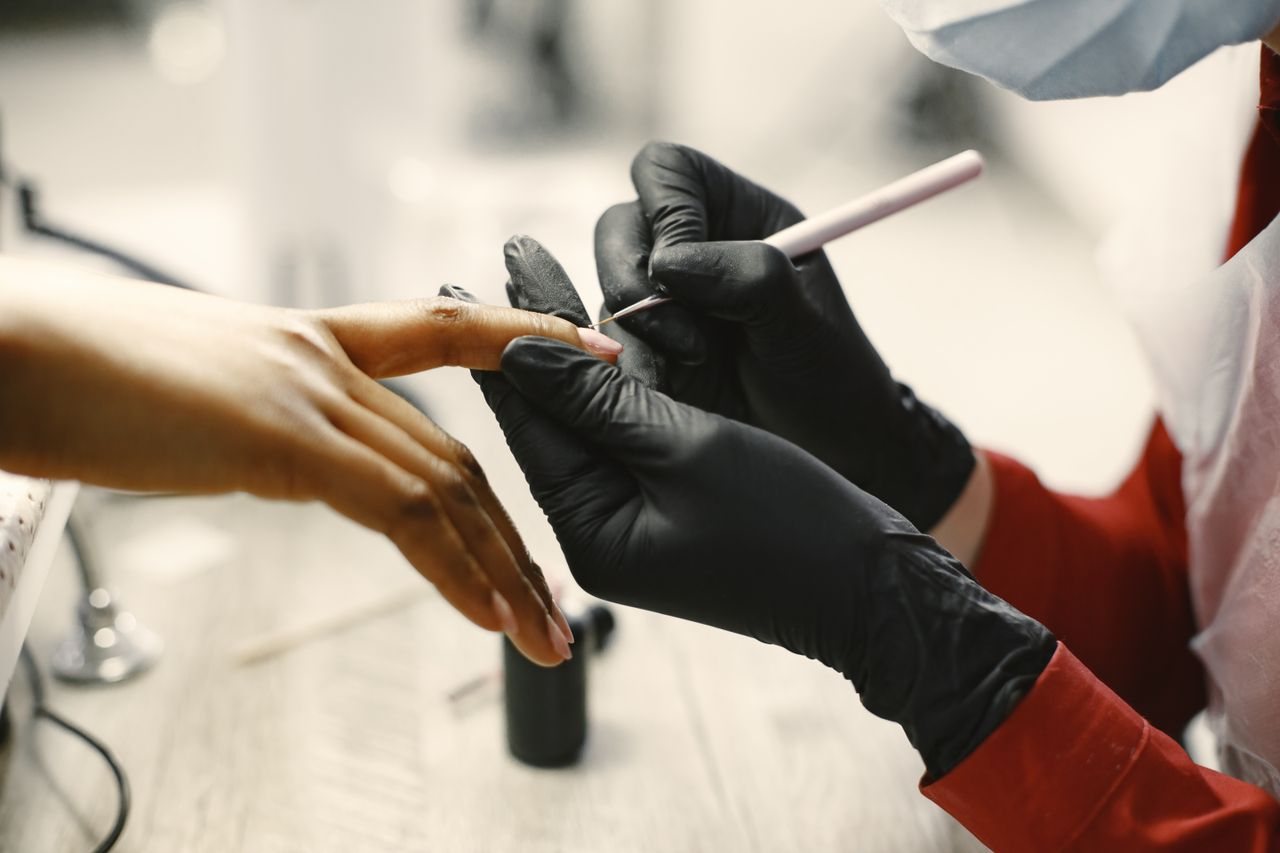Free Close-up of a professional manicure session with tools and black gloves in a modern salon. Stock Photo