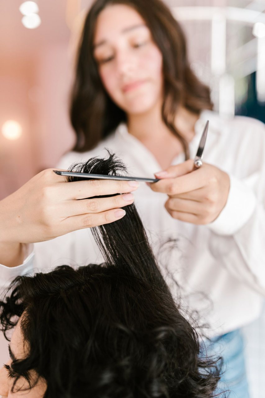 Free Close-up of hairstylist expertly cutting client’s hair in a salon setting. Stock Photo
